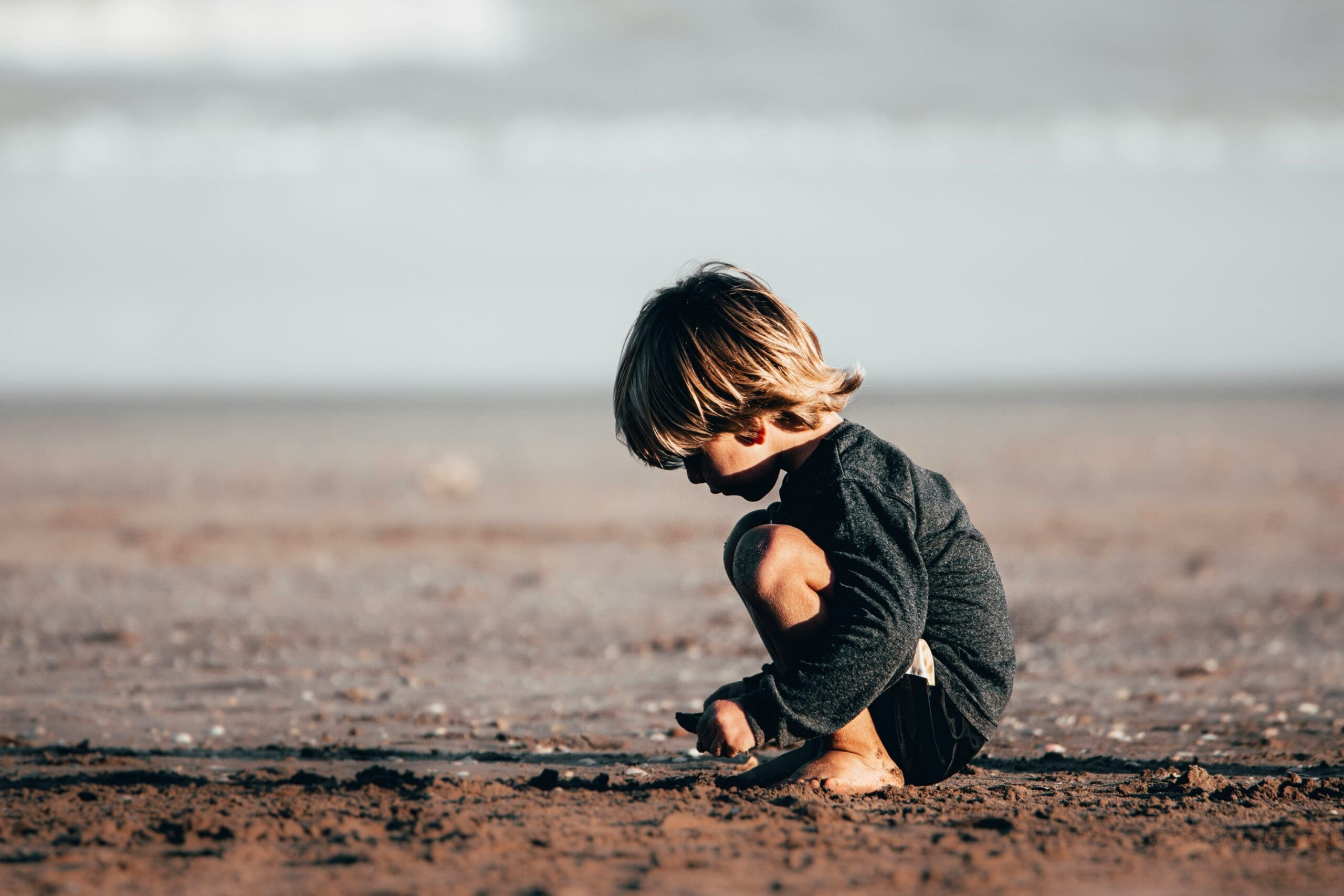 enfant accroupi sur la plage
